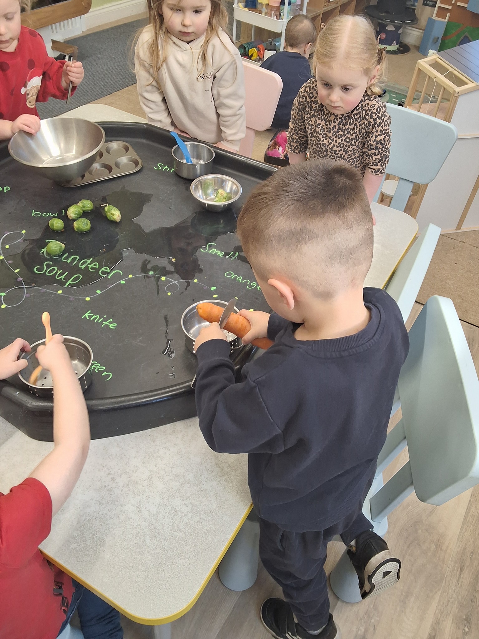 Toddlers building with colourful wooden blocks